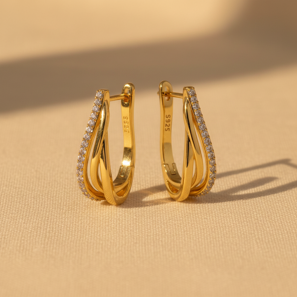 Gold earrings on ivory surface