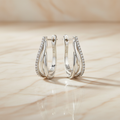 Silver earrings on marble surface